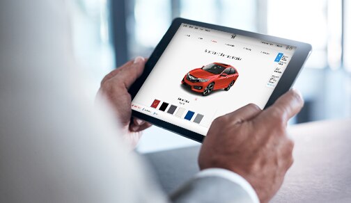Person holding a tablet, visiting the Honda website
